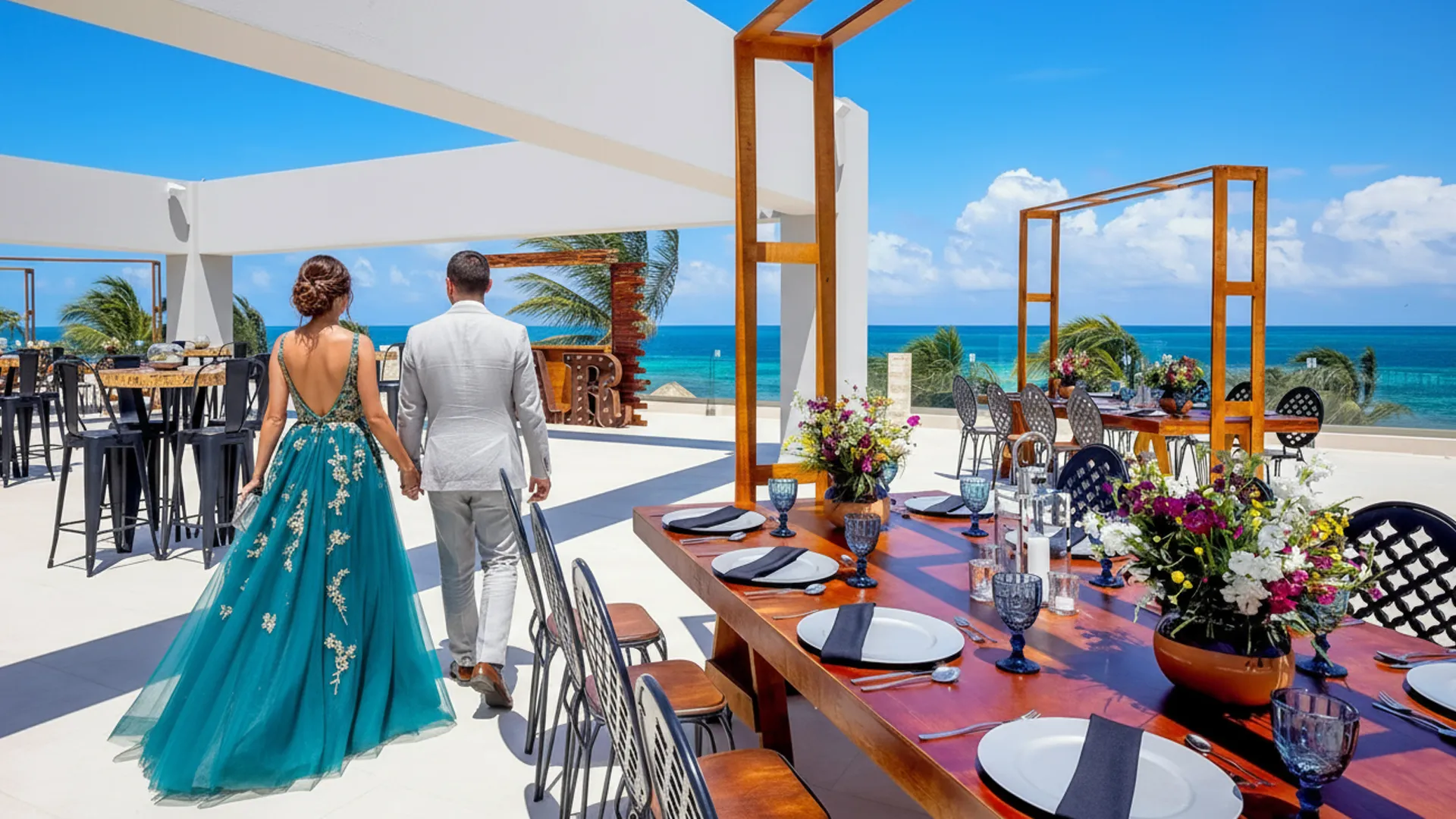 Couple walking hand in hand on a decorated rooftop wedding terrace overlooking the Caribbean at Royalton Splash Riviera Cancun.