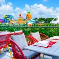 Colorful outdoor dining terrace at Nickelodeon Resort Cancun overlooking Aqua Nick waterpark and SpongeBob’s pineapple house.