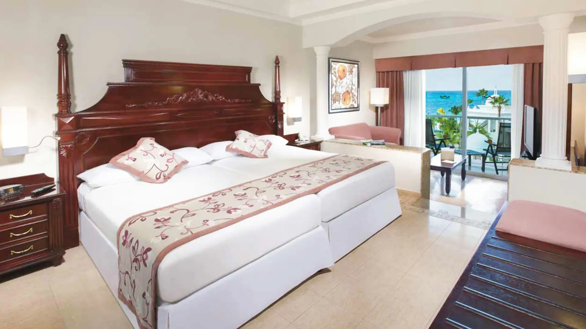 Junior Suite at Riu Palace Las Americas Cancun with classic wooden furniture, sitting area, and ocean-view balcony.