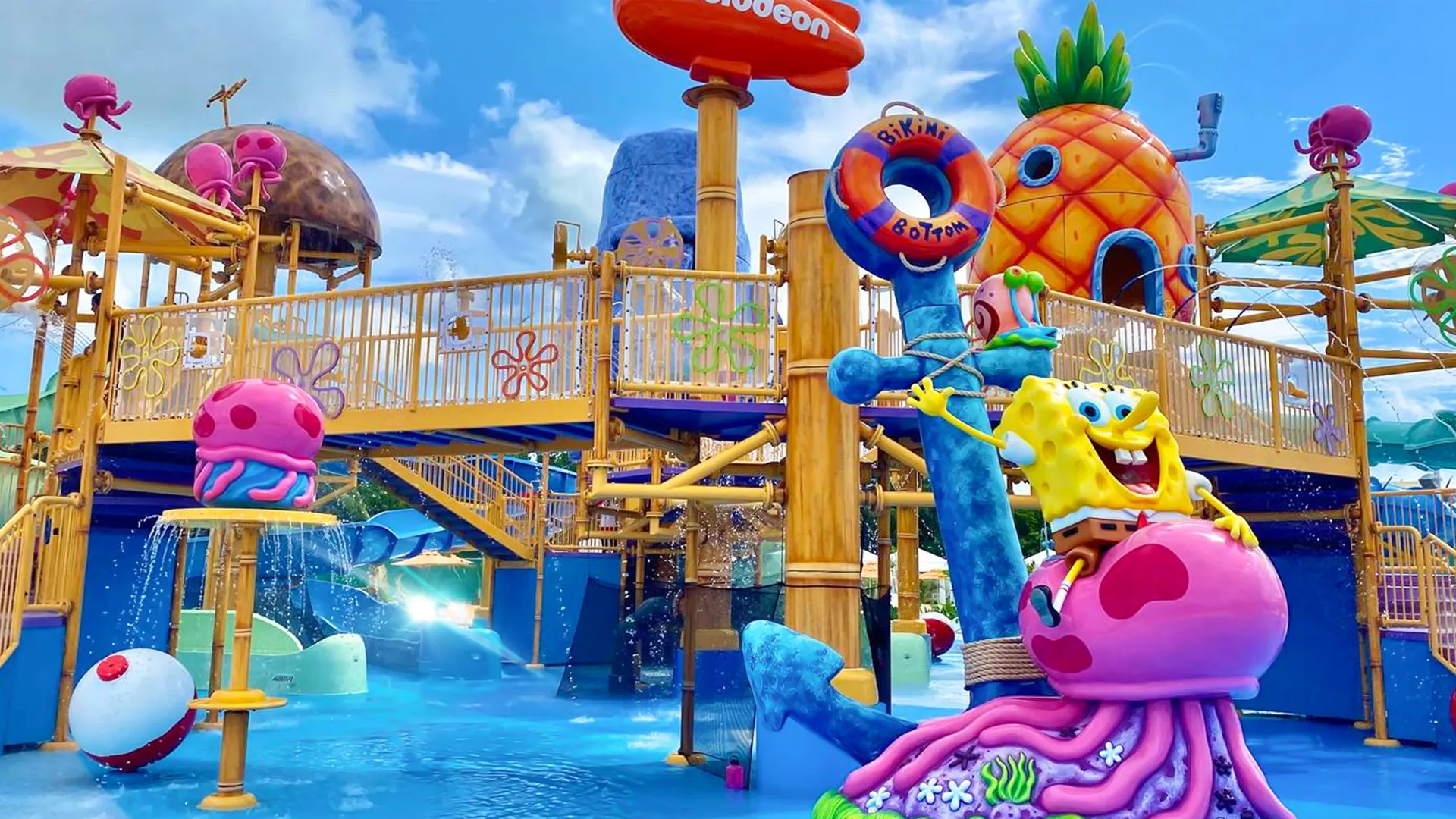 Colorful SpongeBob-themed water playground at Aqua Nick in Nickelodeon Resort Cancun, featuring the pineapple house, slides, and water jets.