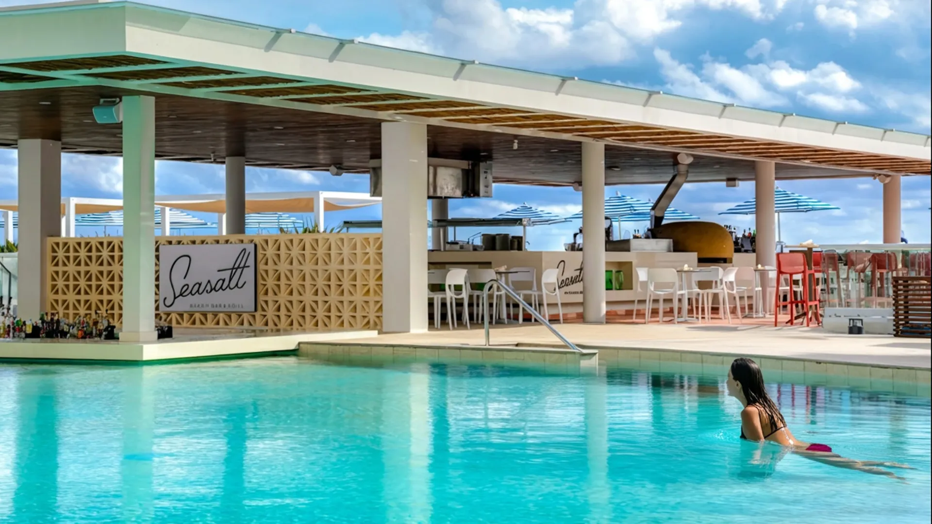 Woman swimming in the pool at Seasalt Beach Bar & Grill, Hilton Cancun.