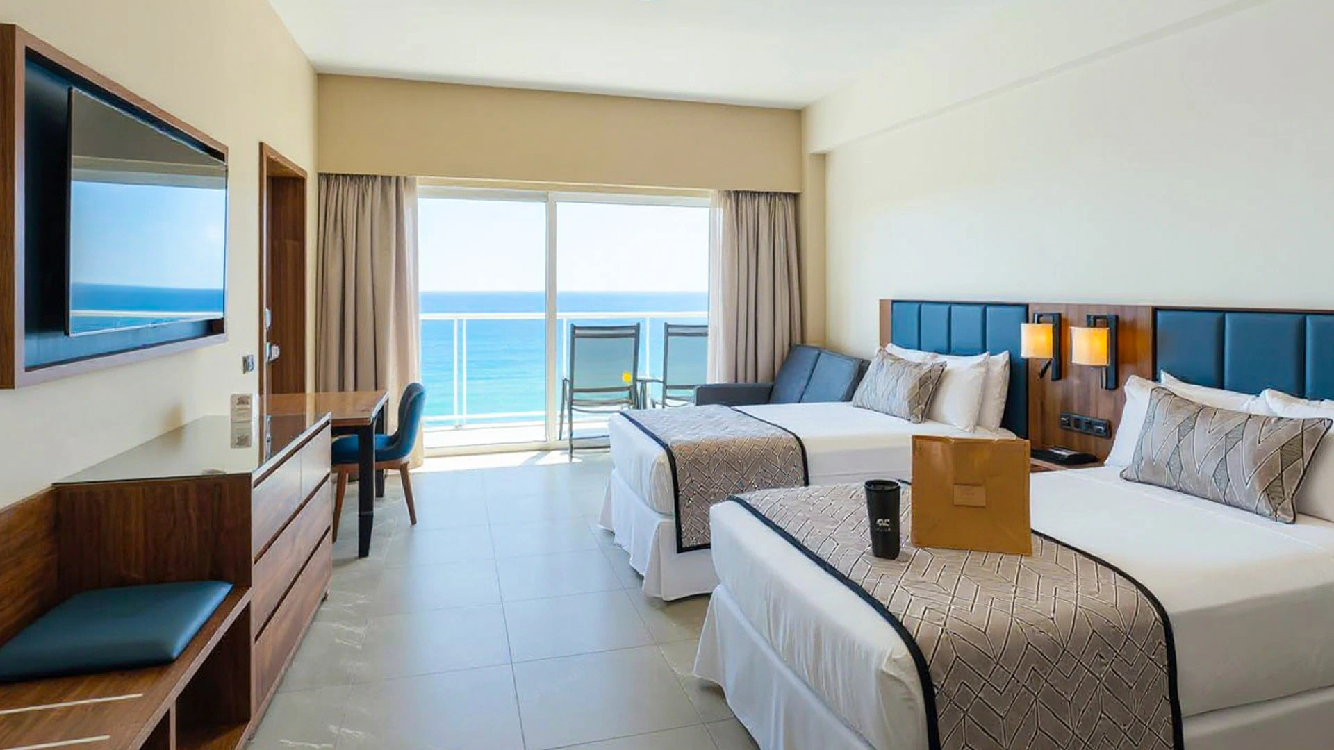 Modern ocean-view room at Temptation Cancun Resort featuring two queen beds, a balcony with turquoise sea views, and sleek contemporary decor.