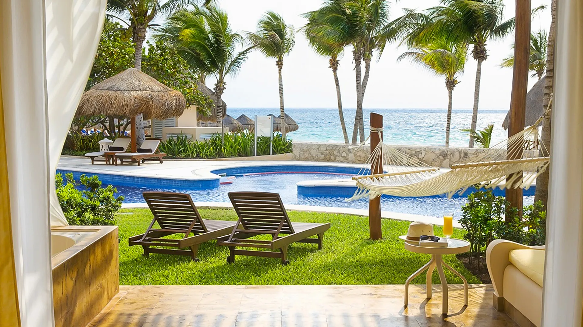 private terrace with hammock, loungers, and poolside garden view