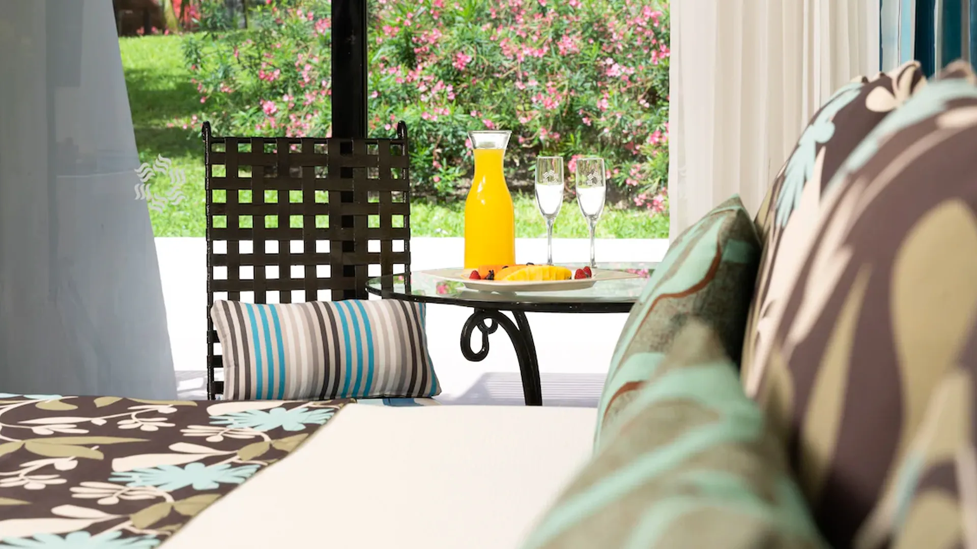 A cozy sitting area with a table set with drinks and fruit, offering a relaxing view at Grand Oasis Cancun.