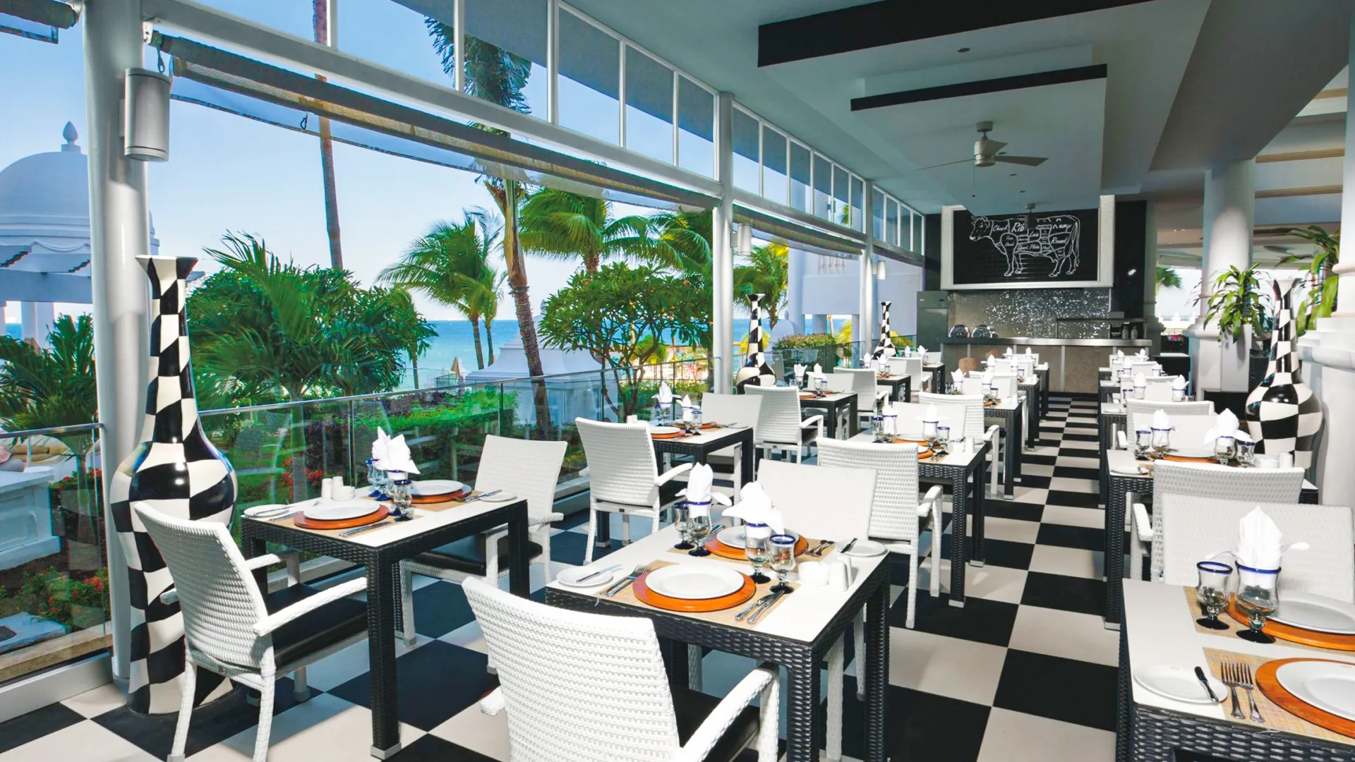 Ocean-view restaurant with modern black-and-white décor at Riu Palace Las Americas Cancun.