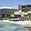 Exterior view of Nizuc Resort Cancun with beachfront cabanas, palm trees, and modern architecture.