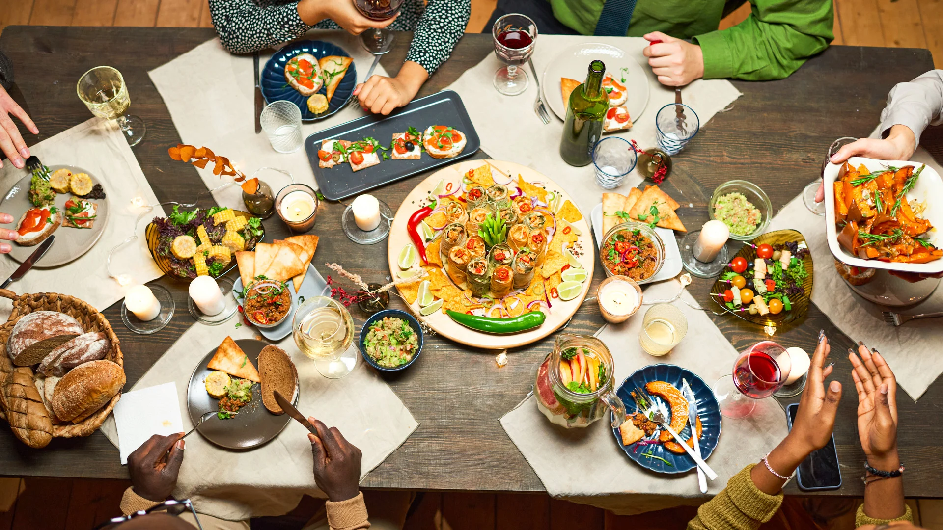Vibrant dinner table at Temptation Cancun Resort filled with colorful dishes, cocktails, and guests enjoying a lively evening.