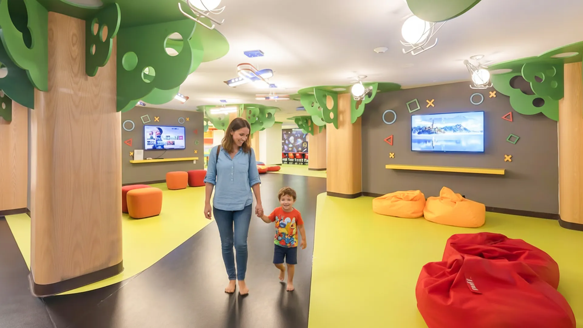 Mother and child walking hand in hand inside the colorful kids club at Royalton Splash Riviera Cancun, surrounded by bean bags, playful decor, and interactive TV screens.