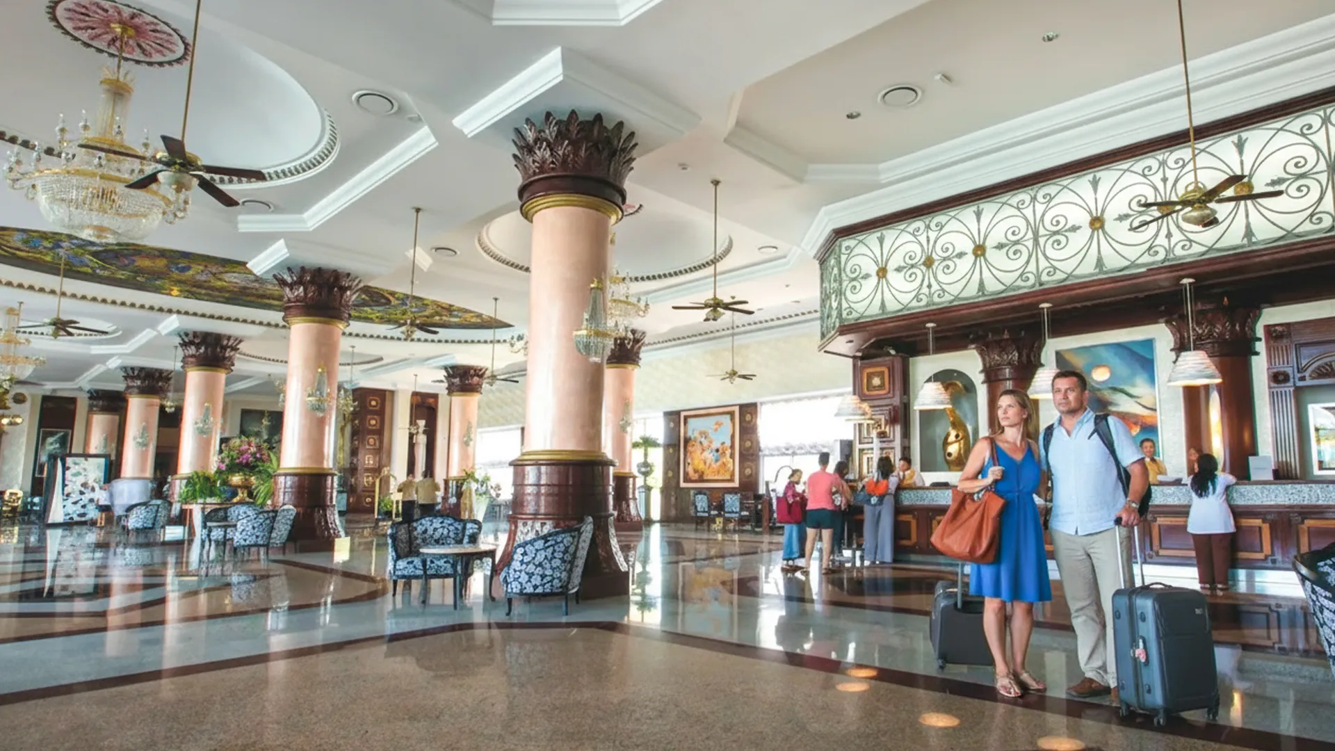 Grand lobby of Riu Palace Cancun with marble floors, chandeliers, and guests checking in.