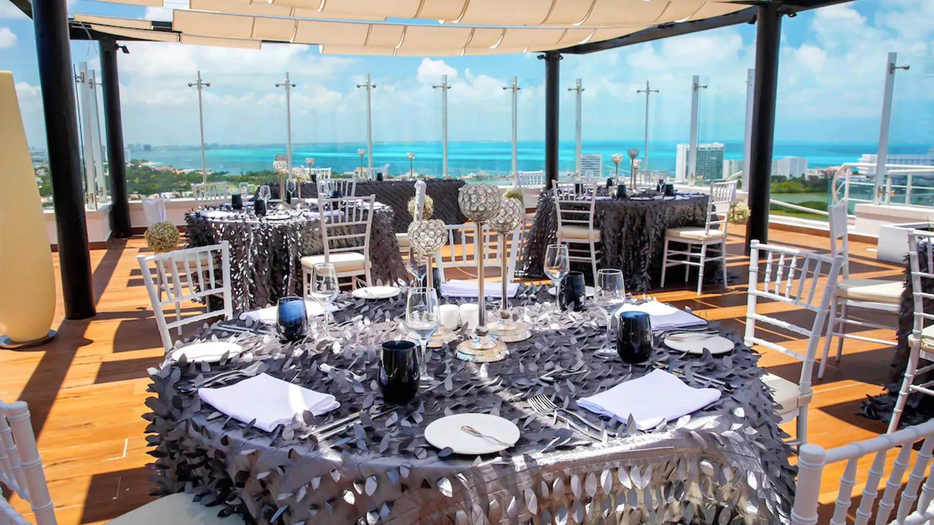 Elegant wedding reception setup with navy blue table décor on the oceanfront terrace at Royalton Cancun.