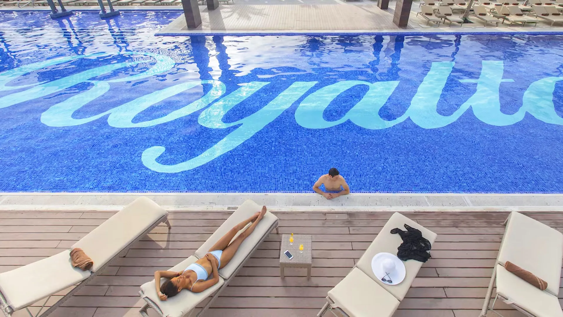Couple enjoying champagne in rooftop Jacuzzi with ocean view at Royalton Cancun Resort.