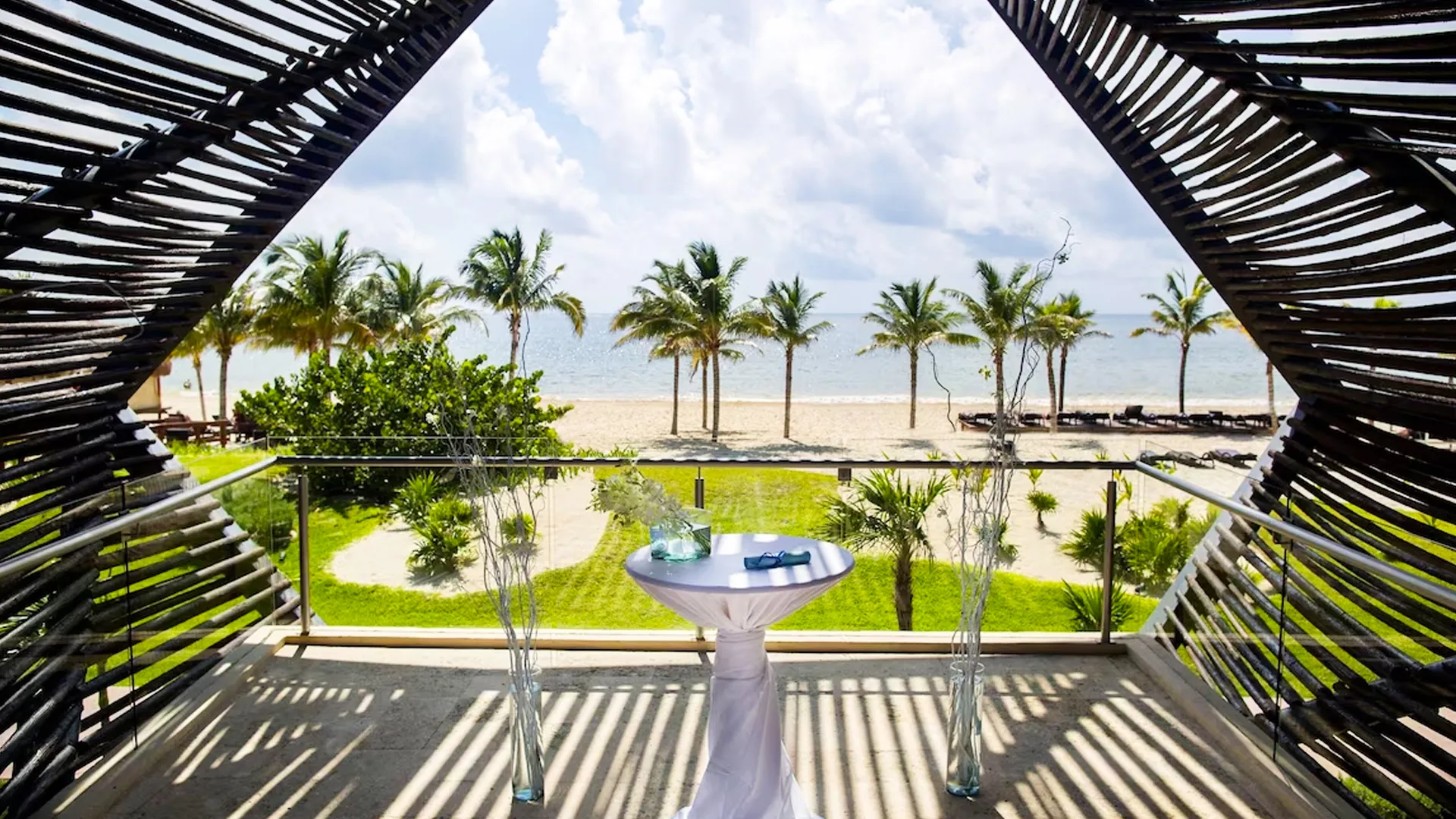 Romantic beachside terrace setup with tropical palm trees and ocean view at Royalton Riviera Cancun.
