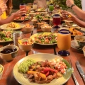 Colorful buffet table at Xplor Park with fresh salads, grilled meats, tropical fruits, and refreshing drinks
