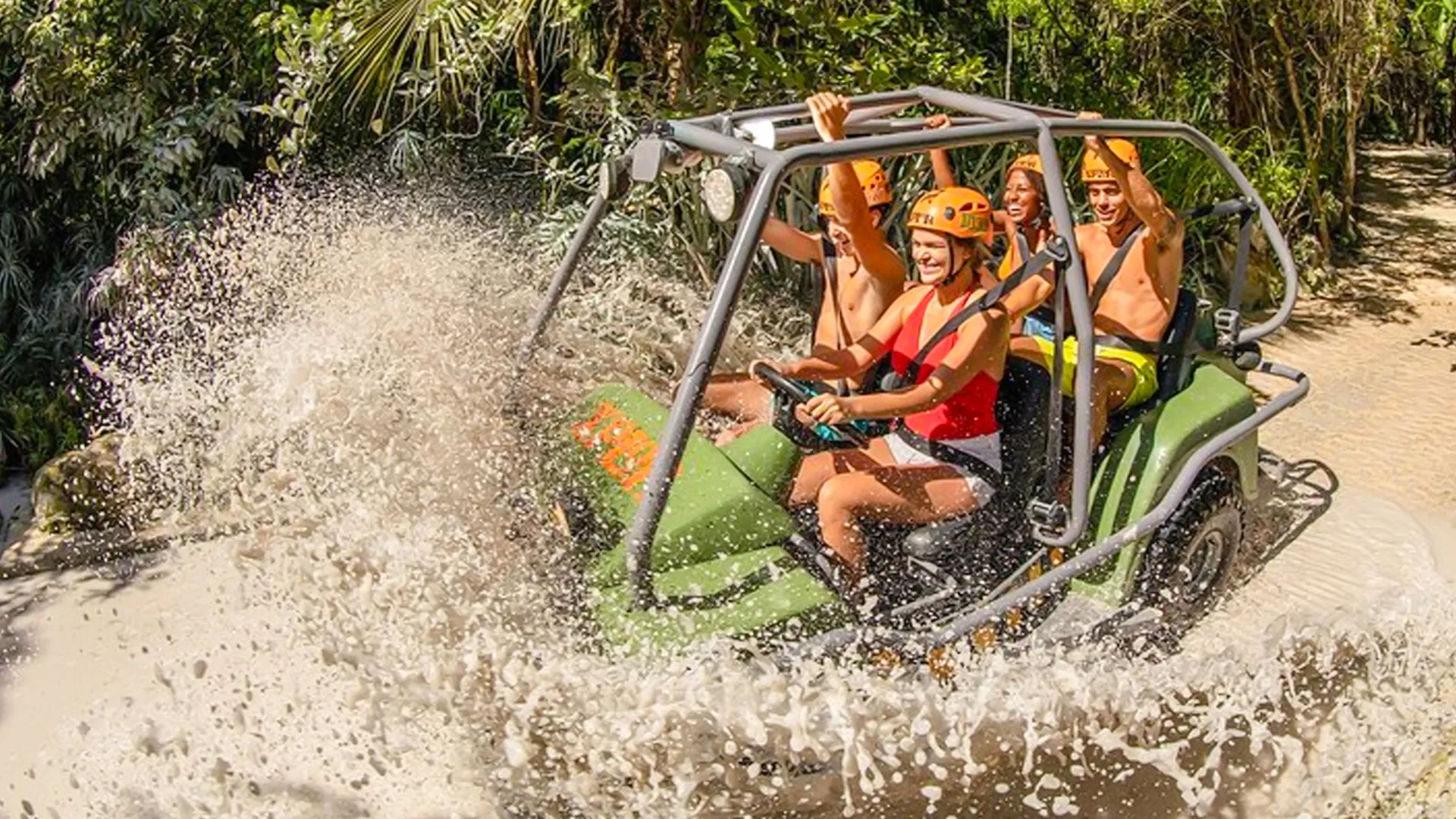 Group of friends driving an amphibious vehicle splashing through muddy water at Xplor Park.