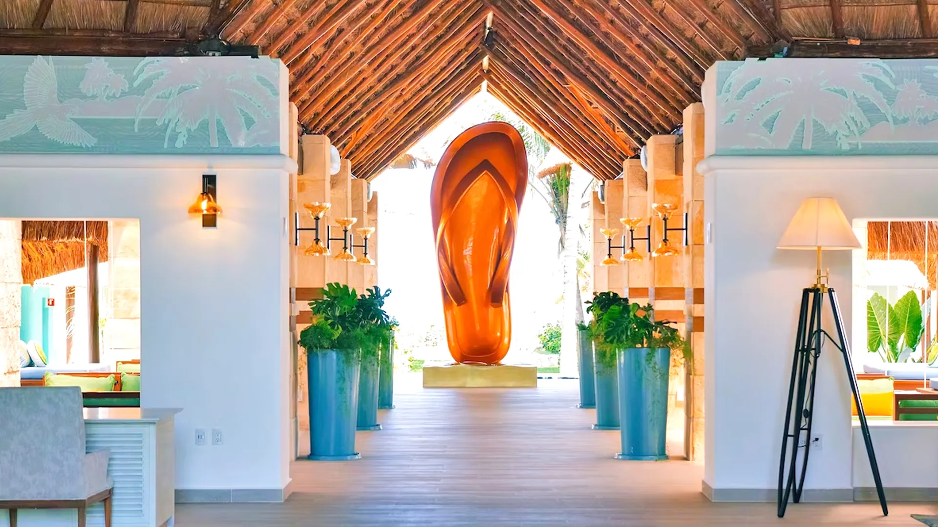 Colorful lobby entrance of Margaritaville Island Reserve Riviera Cancun featuring the resort’s signature giant flip-flop sculpture and tropical decor.