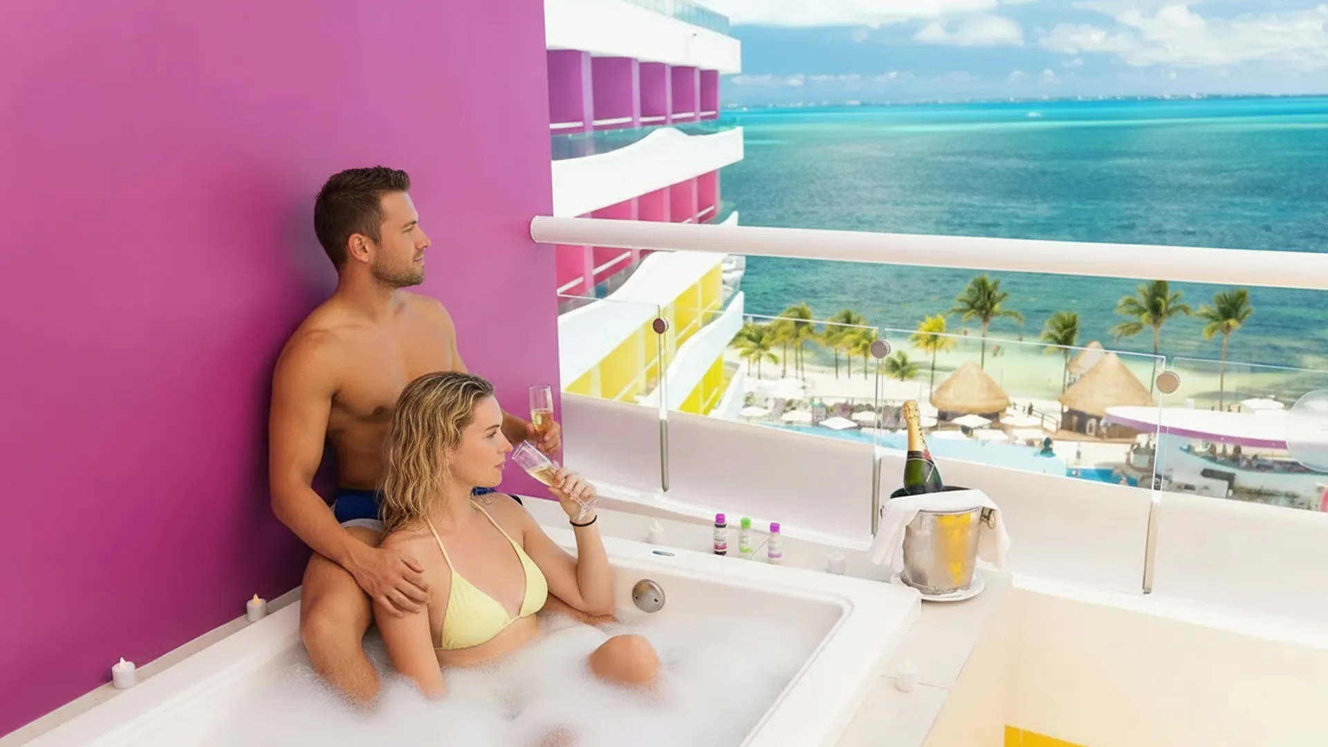 A couple in a hot tub enjoying champagne with a scenic ocean and resort view, surrounded by colorful decor and a bottle in an ice bucket.