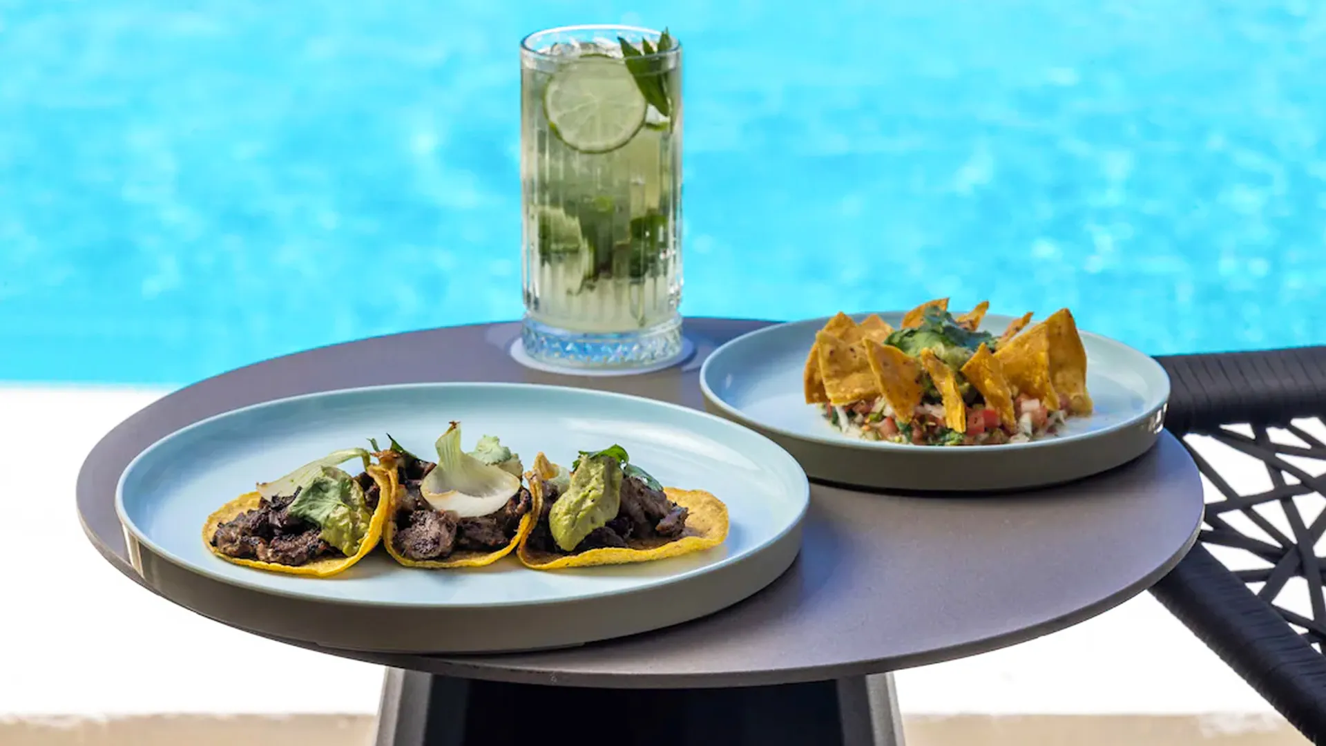 A plate of food and a refreshing drink by the poolside at Sun Palace Cancun.