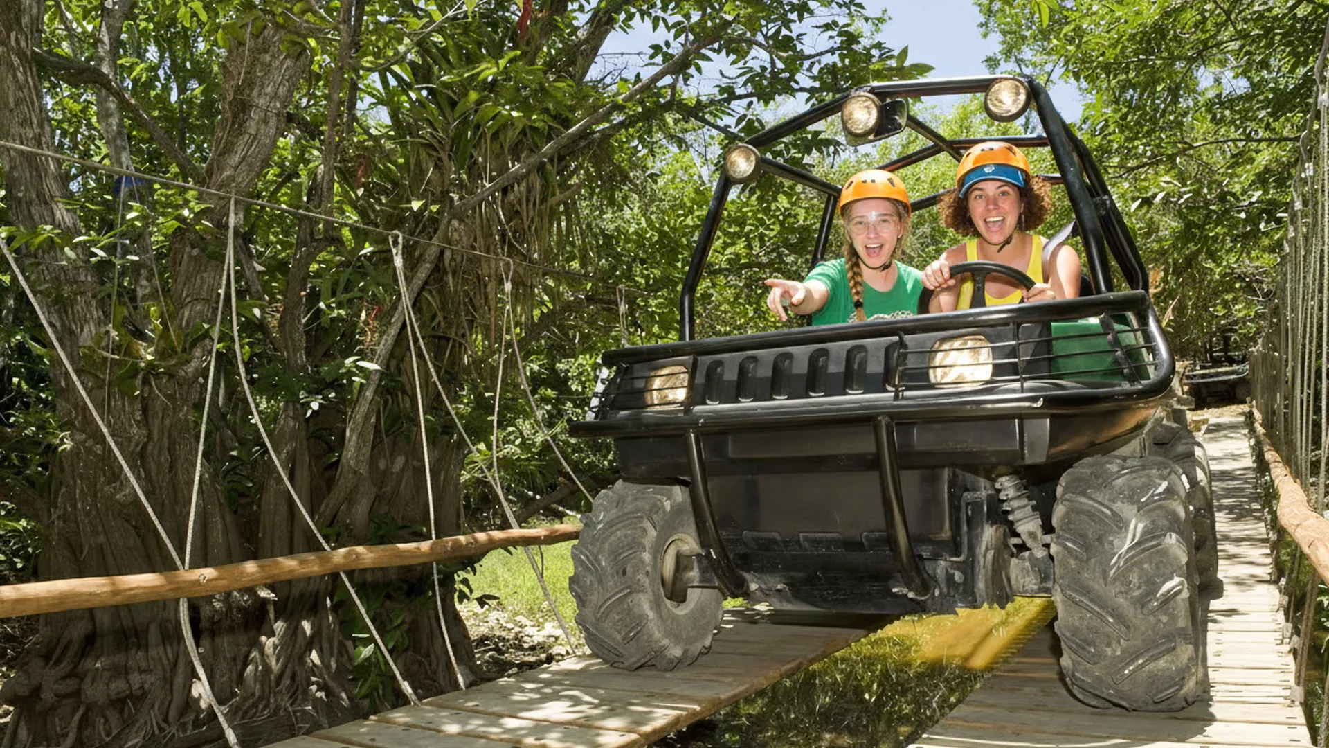 Tourists driving amphibious vehicles through jungle trails at Xplor Park.