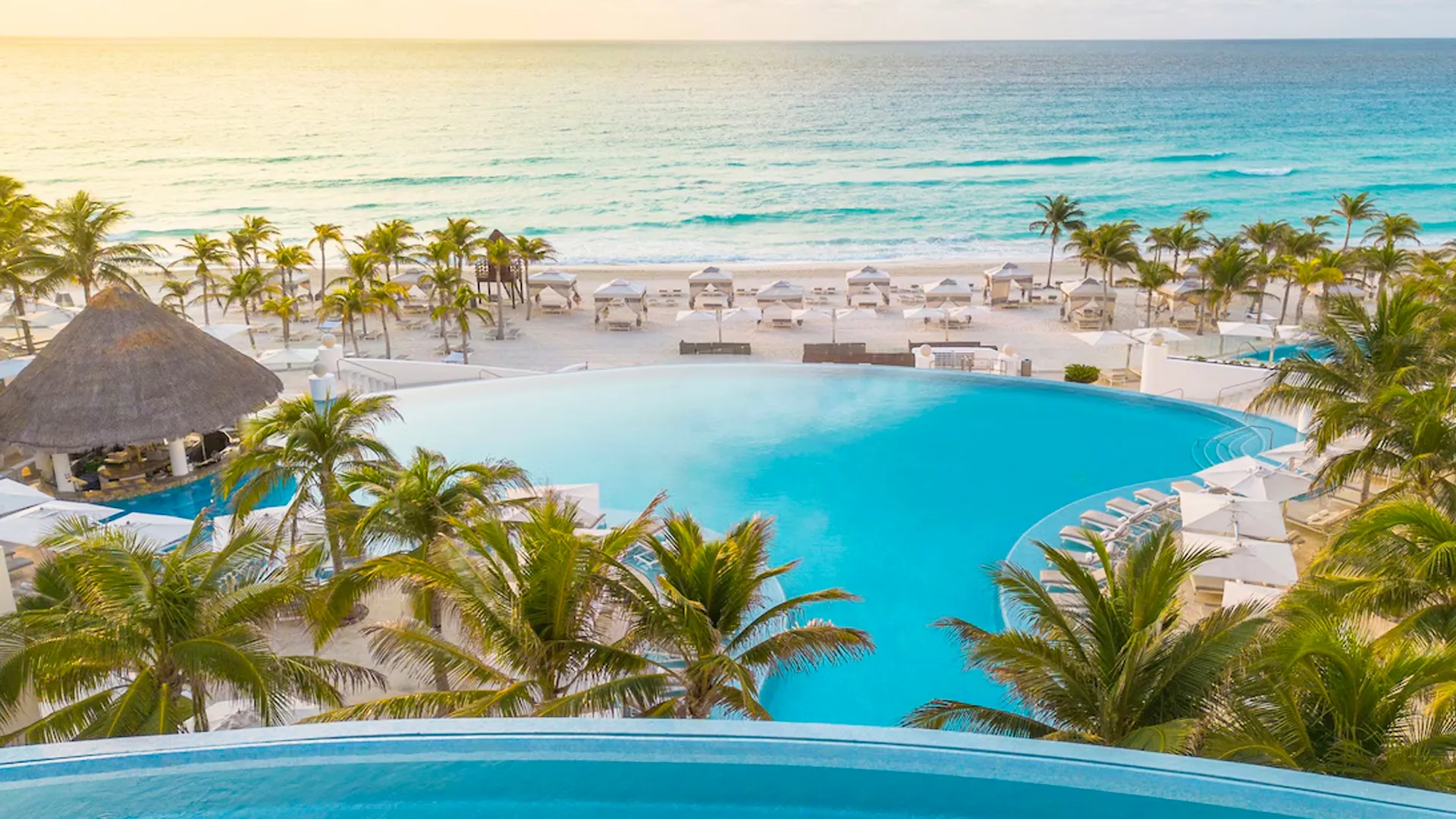 A scenic view of the infinity pool and the beach at Le Blanc Cancun.