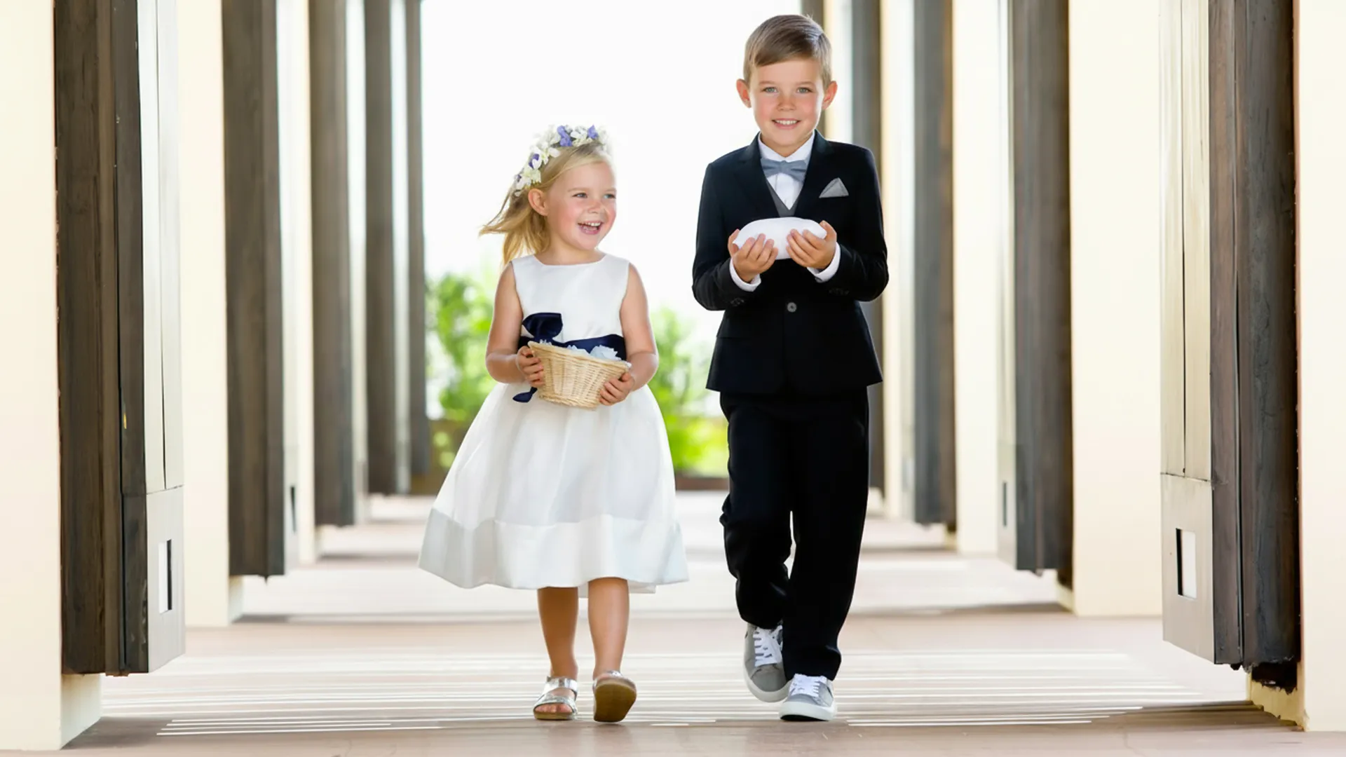 Two children dressed for a wedding walking down the hallway at Royalton Riviera Cancun resort.