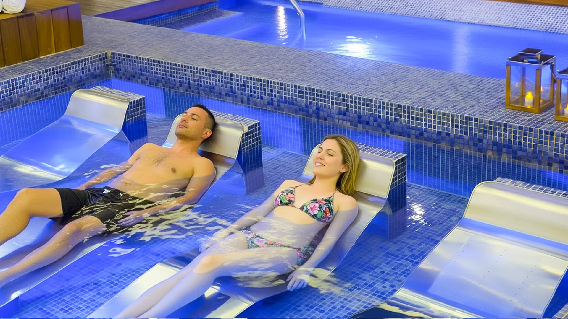 Couple relaxing on in-water loungers at the Royalton Riviera Cancun spa pool.