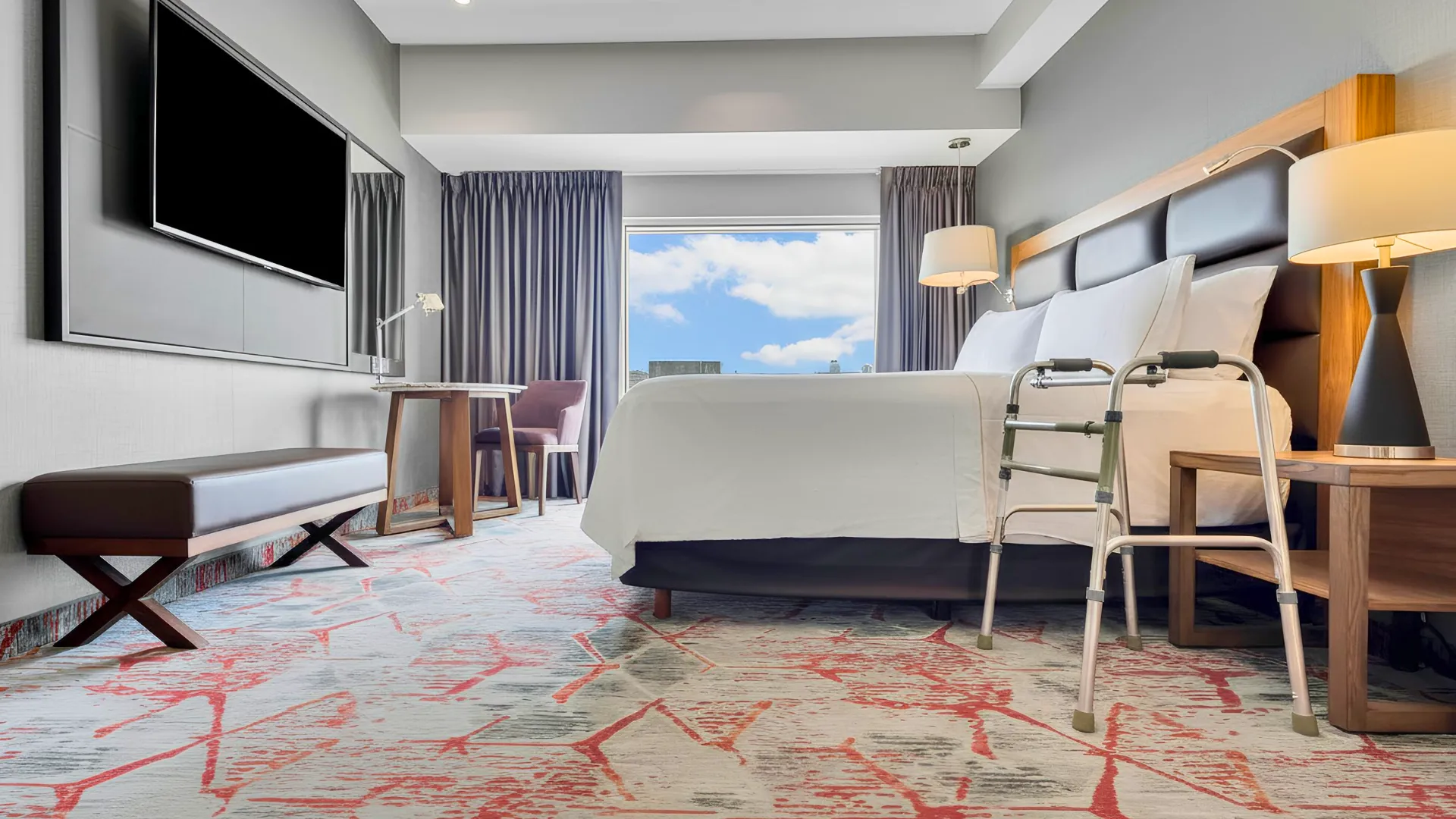  Accessible guest room at Fiesta Americana Cancun featuring modern design, large bed, and assistive walking equipment.