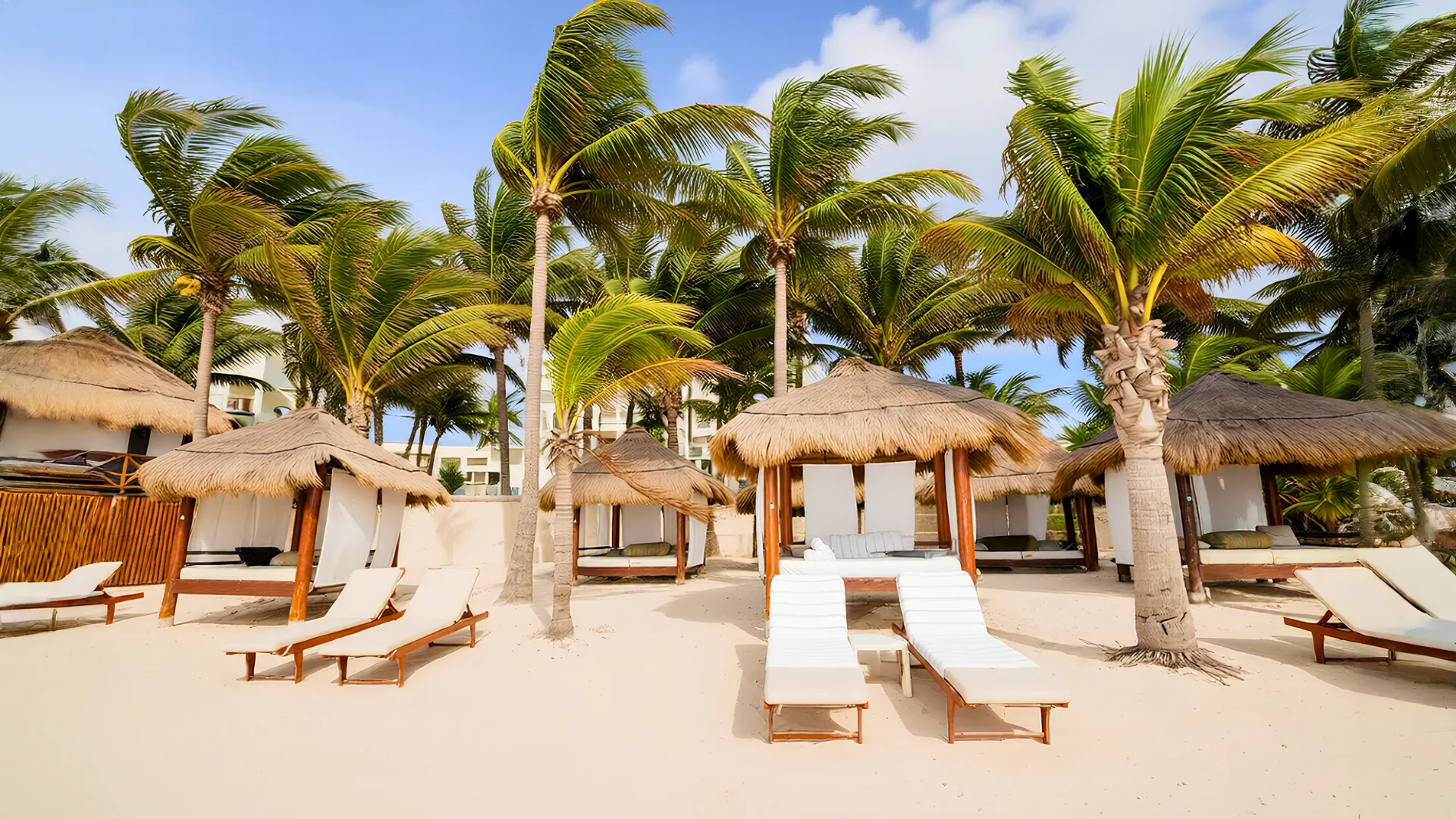 Beachfront cabanas with palm trees at Azul Beach Resort Riviera Cancun.