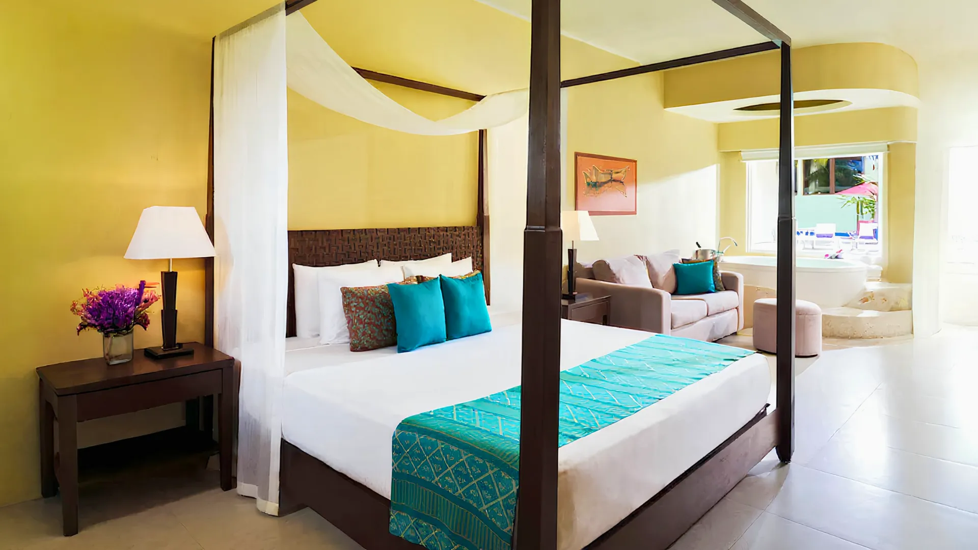 Spacious suite with a canopy bed, jacuzzi, and lounge area at Azul Beach Resort Riviera Cancun.