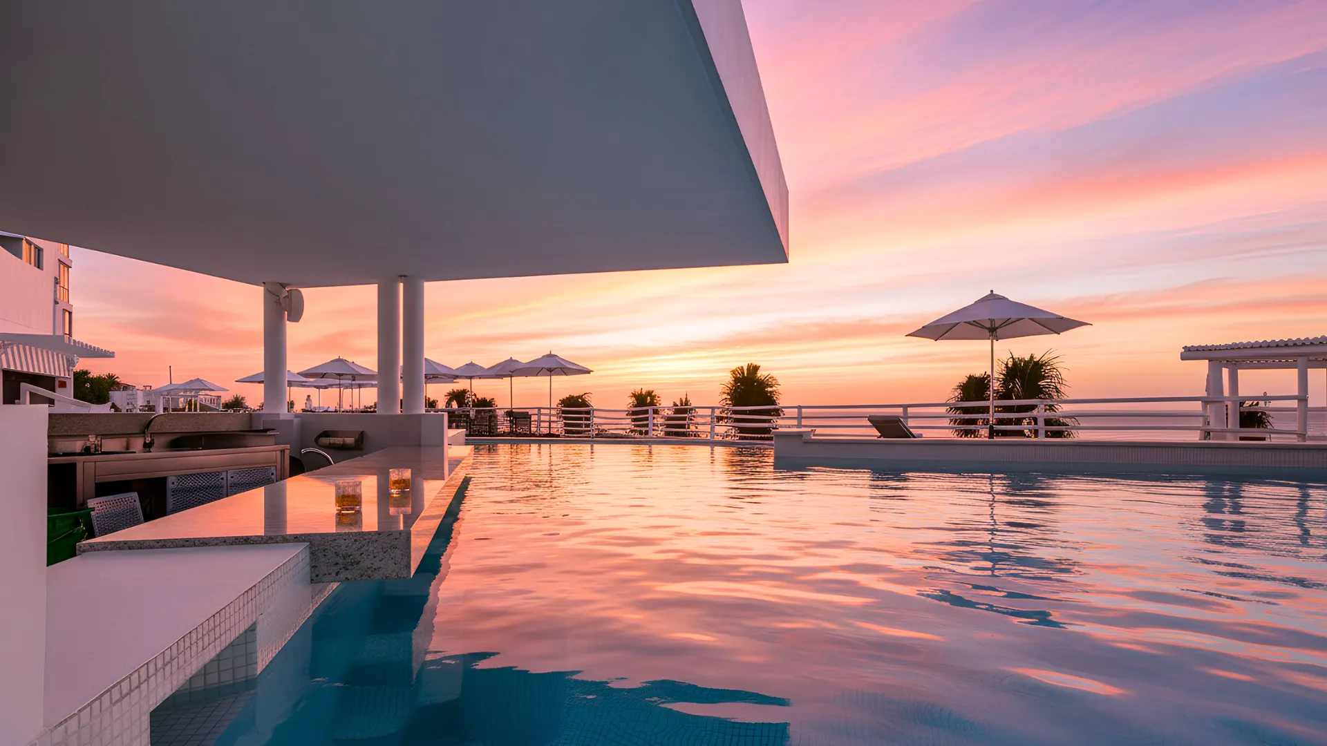 Panoramic view of the resort’s pool and beachfront at Óleo Cancun during sunset, creating a breathtaking experience.