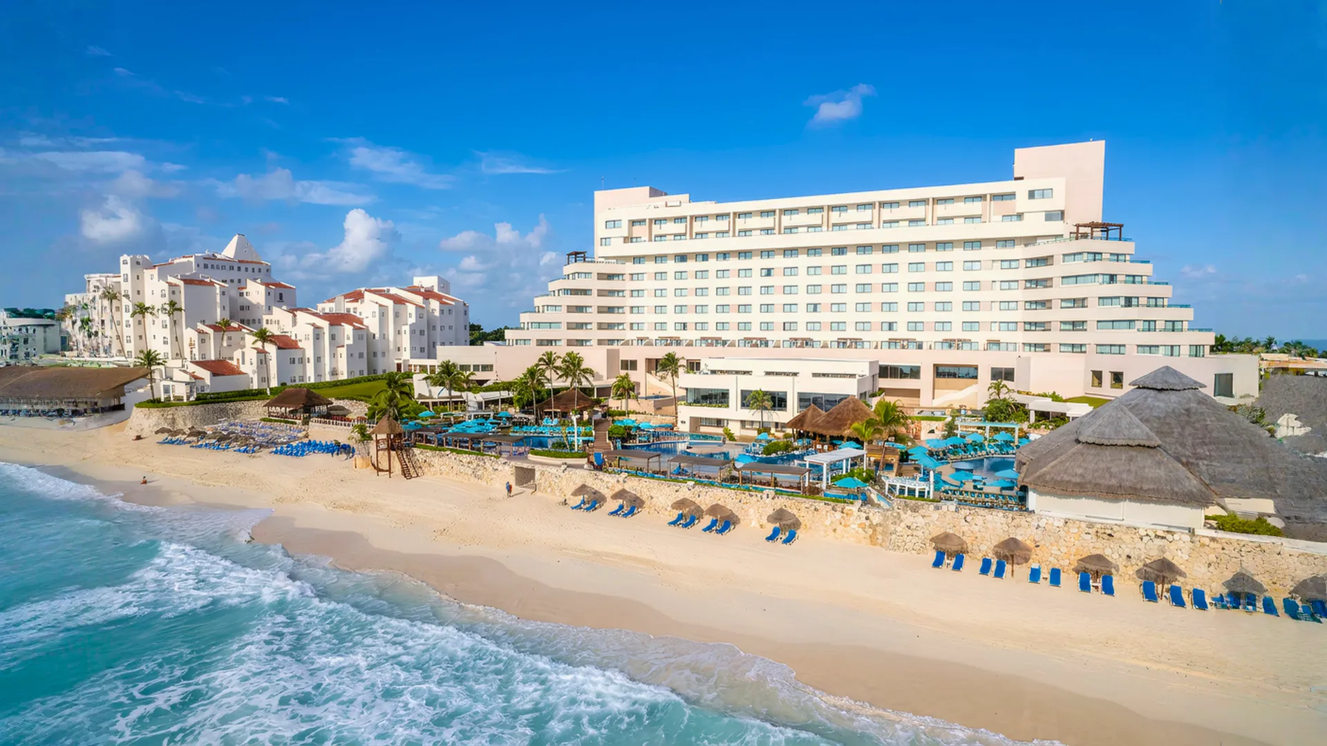 Aerial beachfront view of Royal Solaris Cancun showing the resort buildings, pools, loungers, and turquoise shoreline.