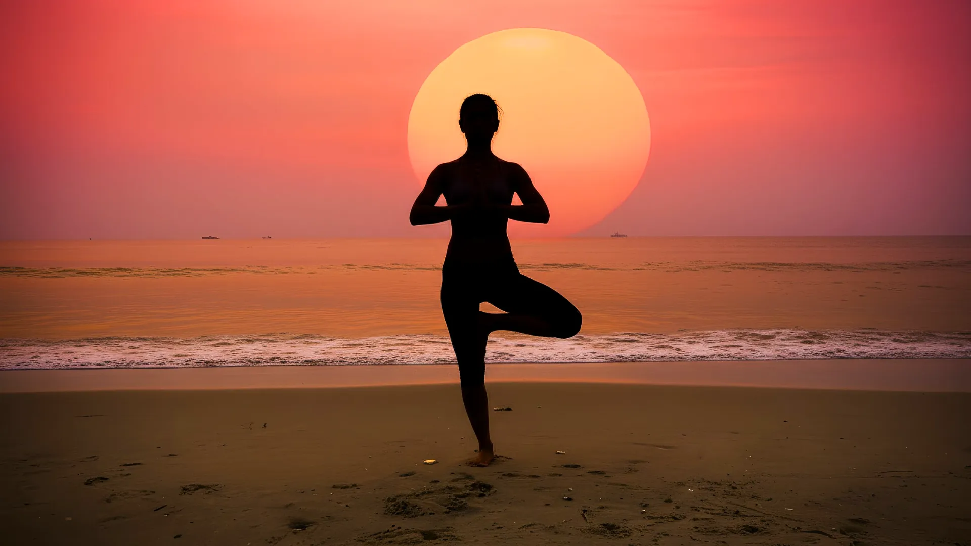 Person doing yoga at sunset on the beach in Cancun.