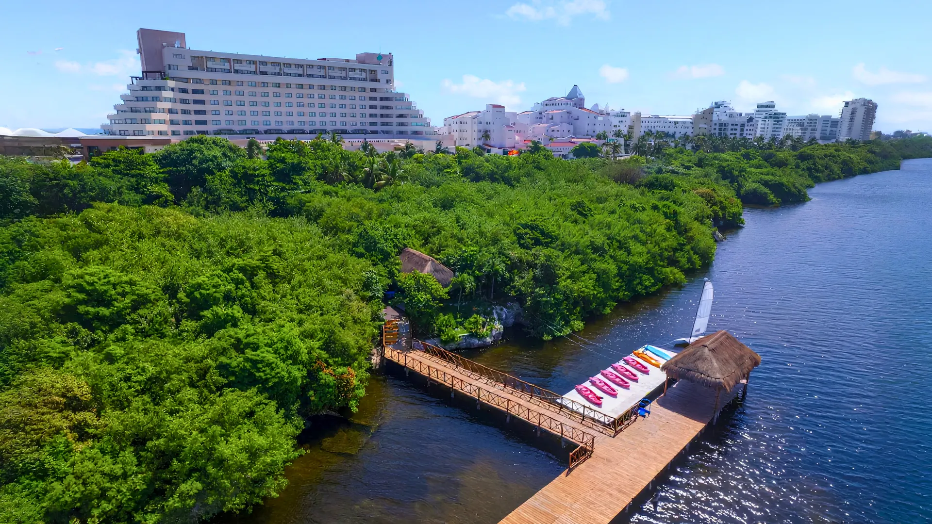 Dock and lagoon-side activities area at GR Solaris Cancun with kayaks and greenery surrounding the water.
Caption