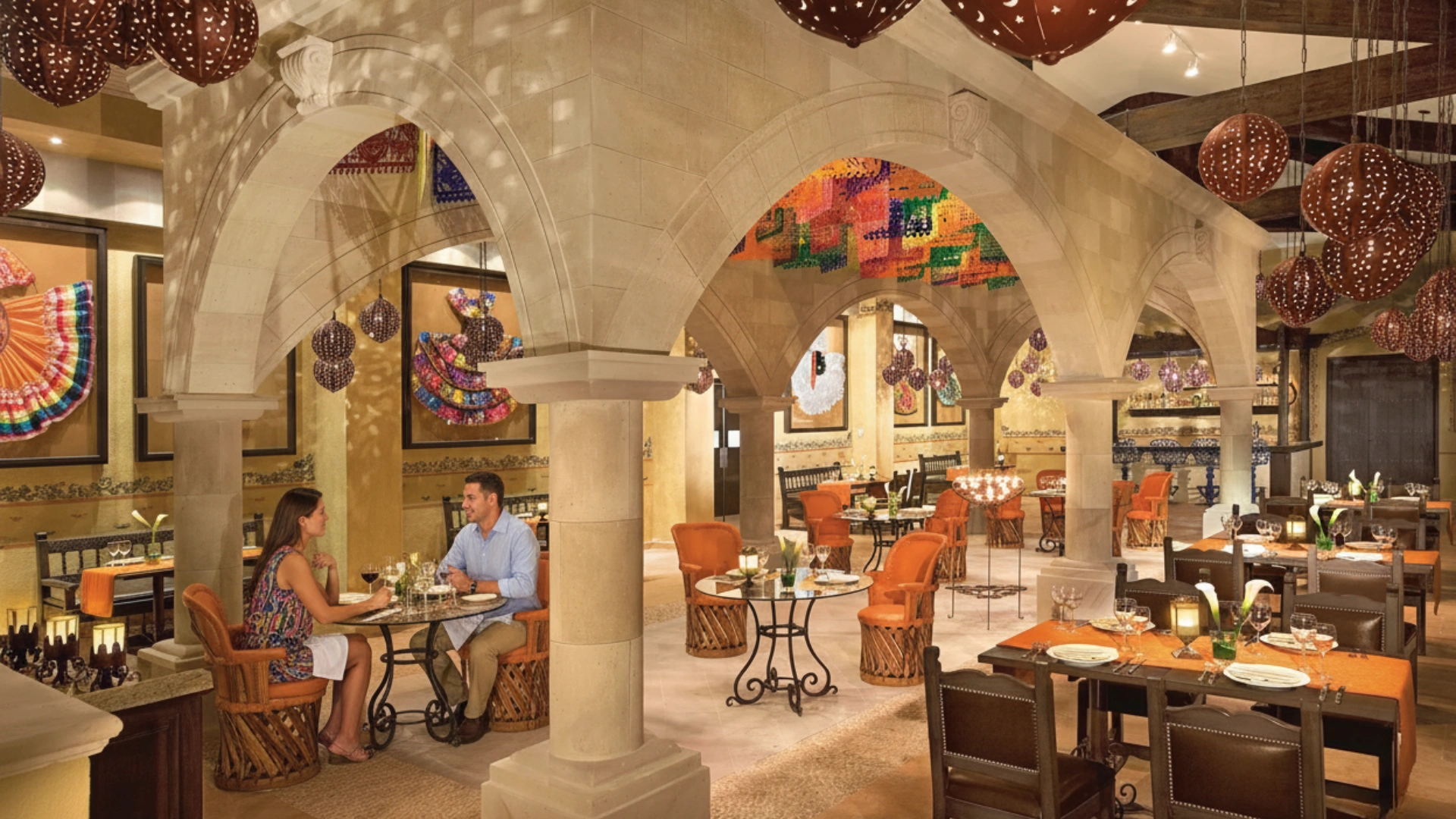 Elegant Mexican restaurant at Dreams Riviera Cancun with colorful décor, arched ceilings, and candlelit dining tables.