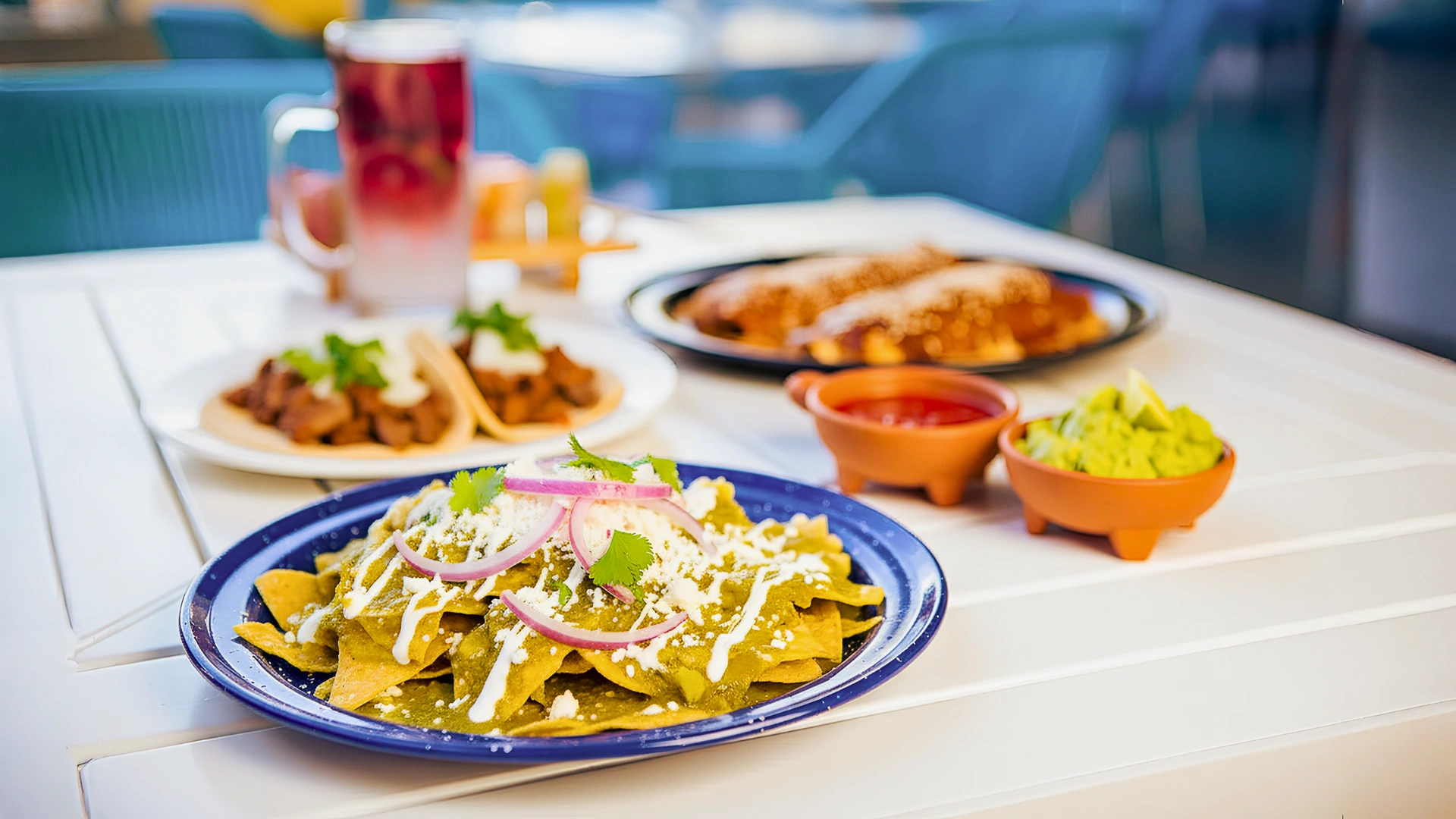 A close-up of a dish with tacos, guacamole, and drinks on a table at a restaurant in Cancun.
