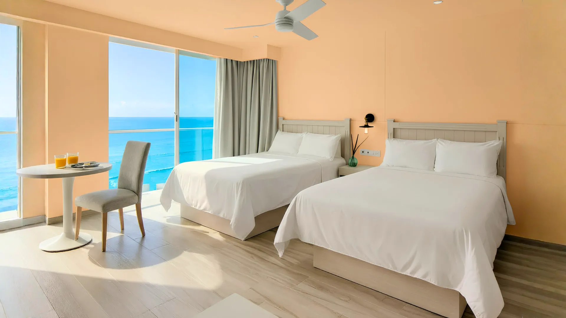 آView of a modern hotel room with oceanfront windows at Óleo Cancun, offering a relaxing stay with scenic views.