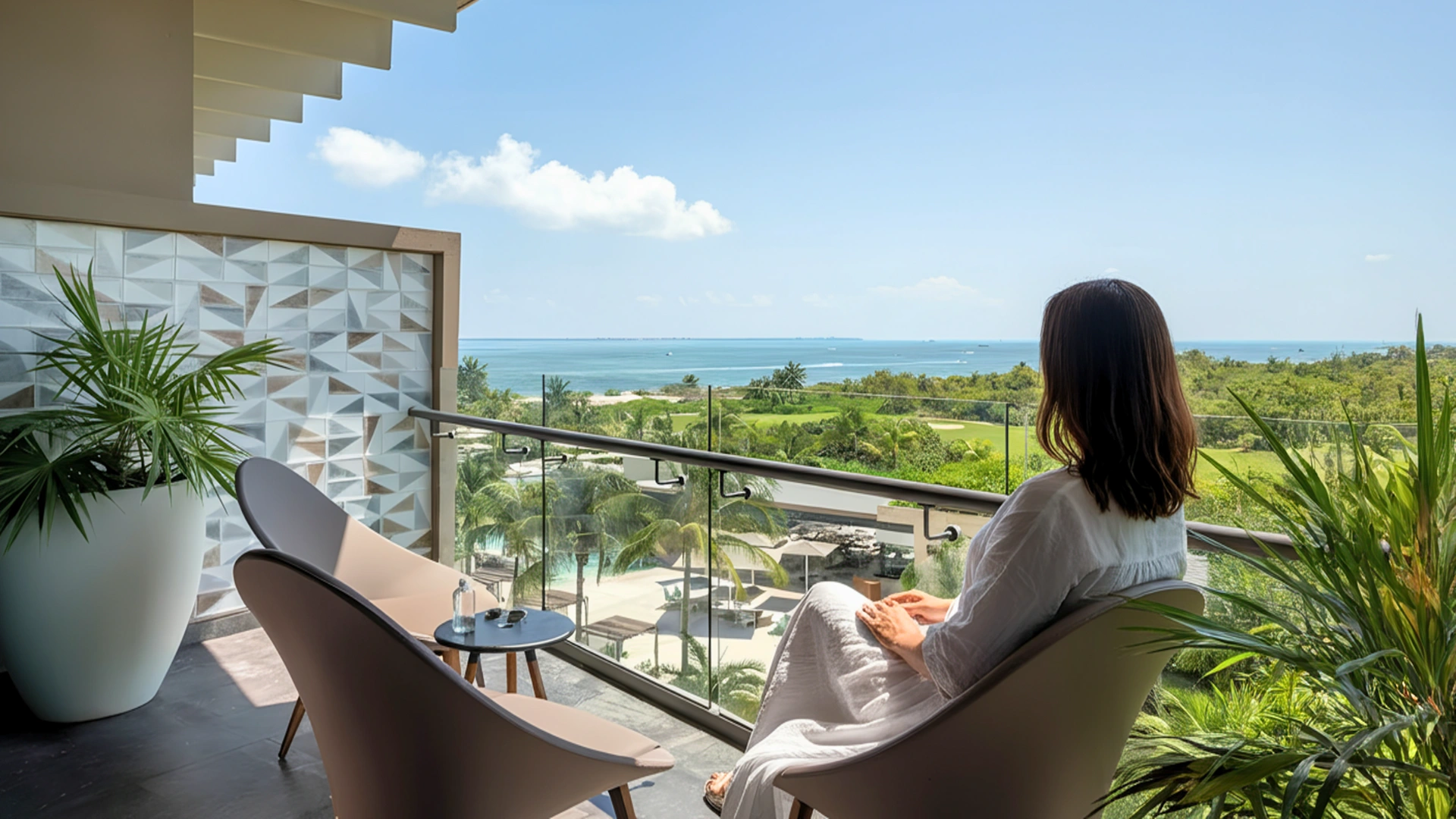 A guest enjoying a serene view of the ocean from a balcony at Atelier Hotel Cancun.