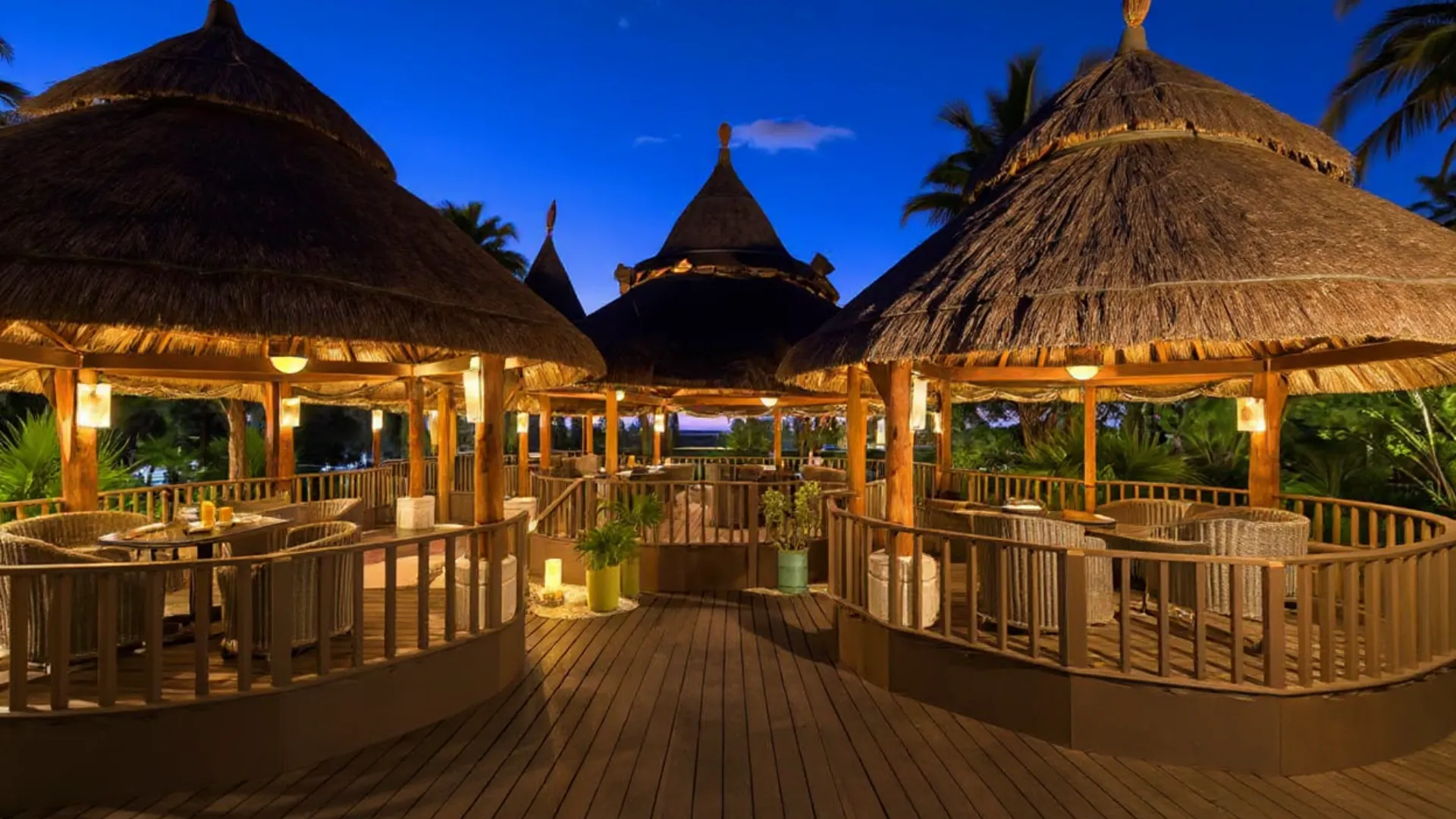 Outdoor palapa-style restaurant at Marriott Cancun illuminated at night, featuring wooden decks, warm lighting, and tropical palm surroundings.