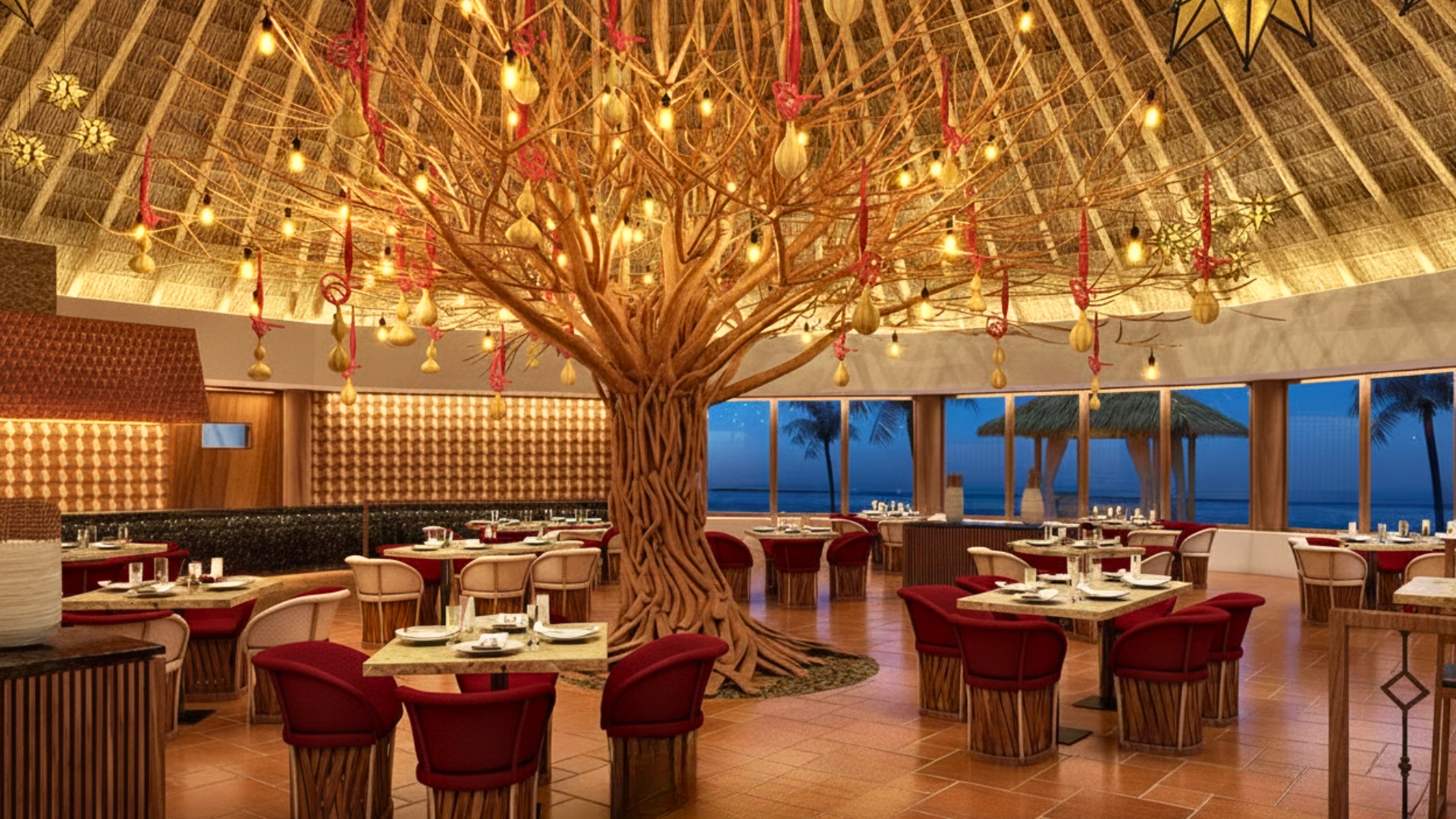 Artistic restaurant at Dreams Riviera Cancun featuring a central tree sculpture, warm lighting, and ocean-view seating.