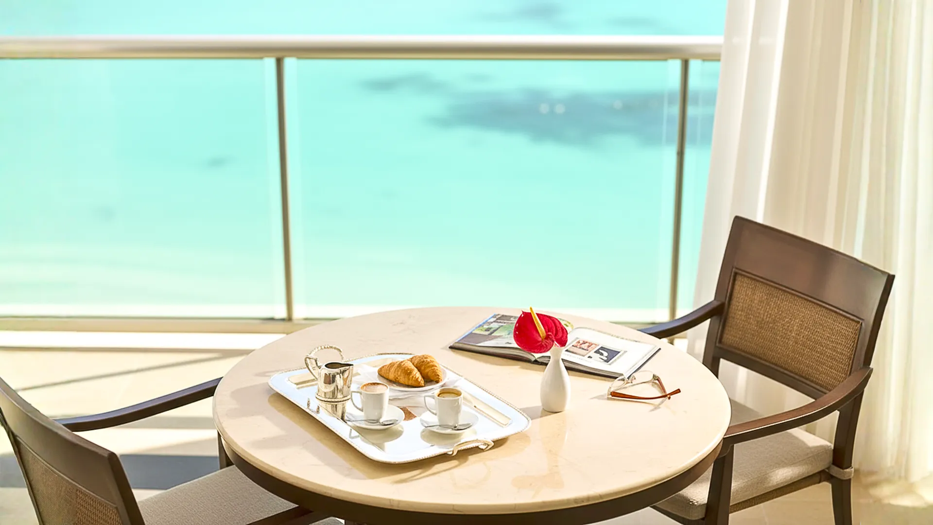 Coffee and pastries served on a balcony table overlooking the turquoise ocean at Grand Fiesta Americana Coral Beach Cancun.