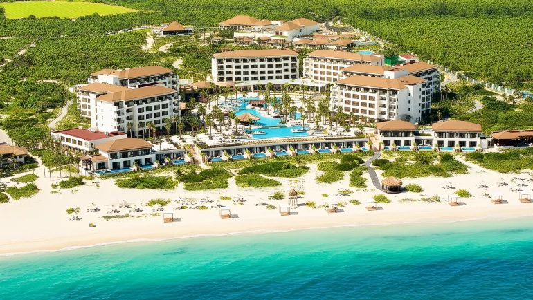 Aerial view of Secrets Playa Mujeres Golf & Spa Resort in Cancun, featuring beachfront suites, turquoise waters, and lush greenery.