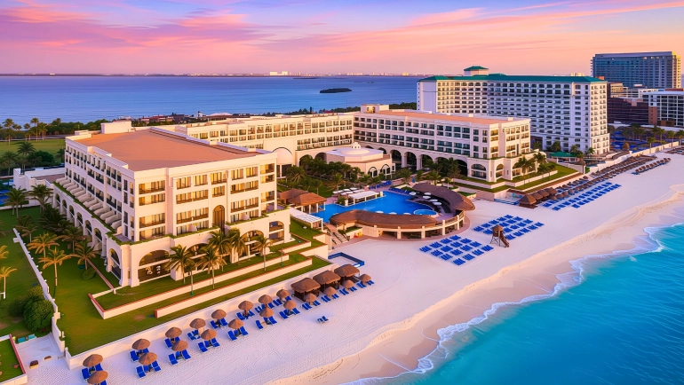 Aerial view of Marriott Cancun Resort at sunset, featuring beachfront pools, white sand, and turquoise Caribbean waters in Cancun’s Hotel Zone.