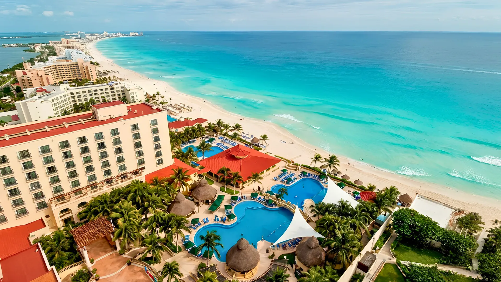 Aerial view of GR Solaris Cancun resort overlooking the white-sand beach and turquoise Caribbean Sea.
Caption