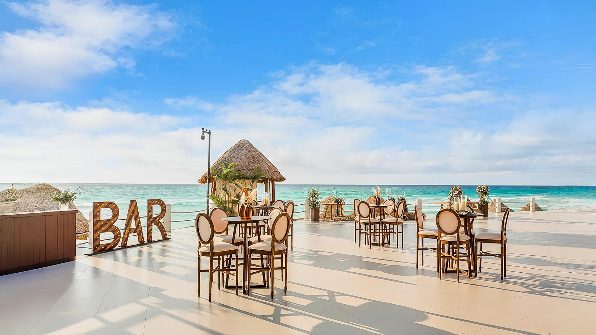 Beachfront bar area at Fiesta Americana Cancun with tables overlooking the turquoise Caribbean Sea.