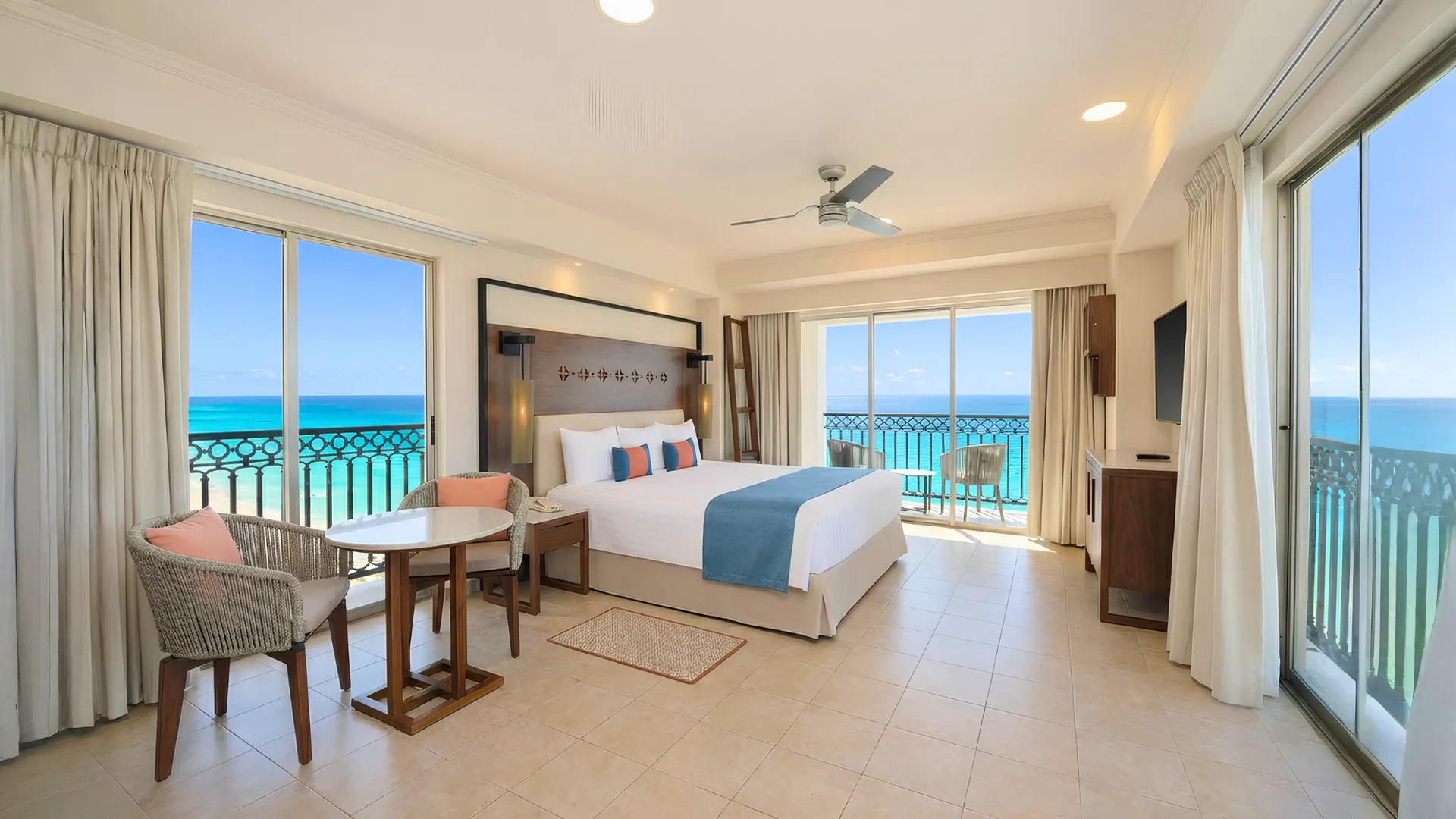 Oceanfront hotel room at GR Solaris Cancun with a king bed, seating area, and large windows facing the Caribbean Sea.
Caption