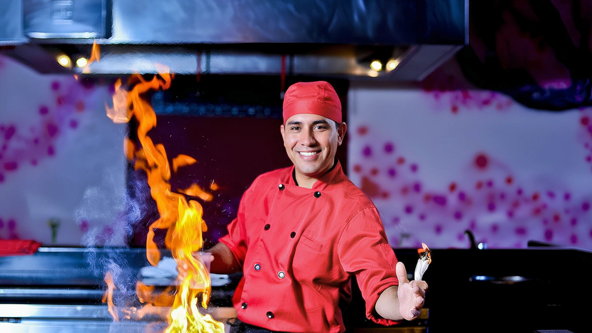 Chef in red uniform performing a flambé dish at Hard Rock Cancun kitchen.