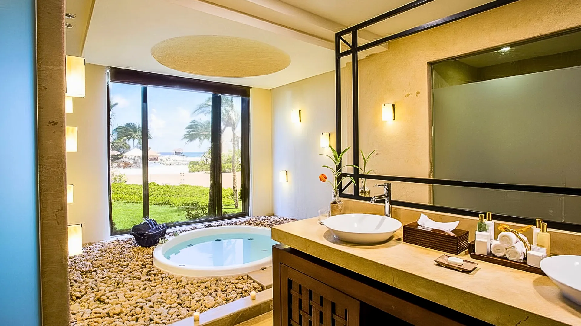 Elegant bathroom at Dreams Riviera Cancun featuring a whirlpool tub, garden view, and natural stone décor.