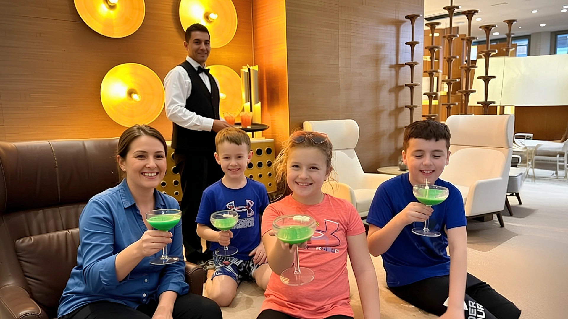 Family enjoying drinks at the Nickelodeon Riviera Maya lounge with friendly resort staff.