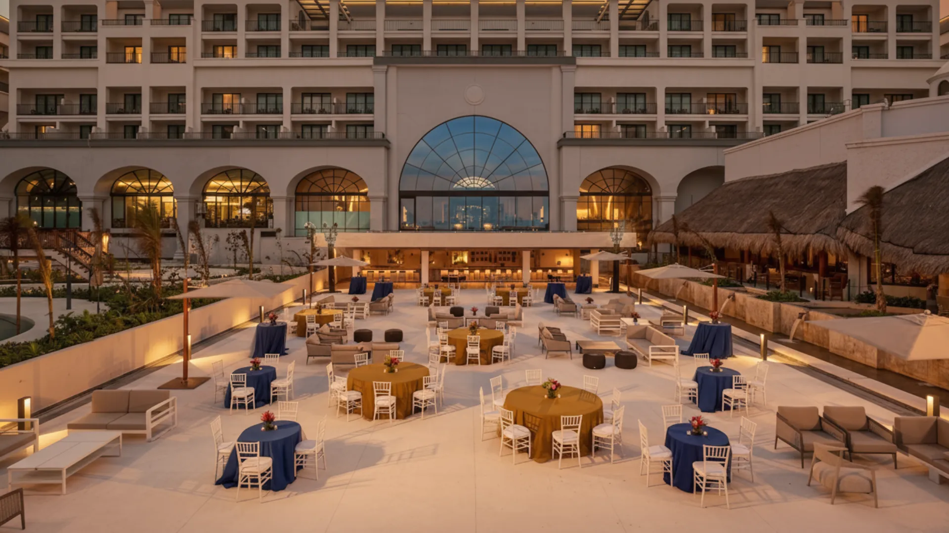 Outdoor evening setup at Marriott Cancun with round tables, warm lighting, and a lively atmosphere for social events and entertainment.