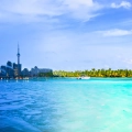 Split image showing Toronto’s icy winter skyline and Cancun’s tropical turquoise waters with palm trees, highlighting the contrast between the two destinations.