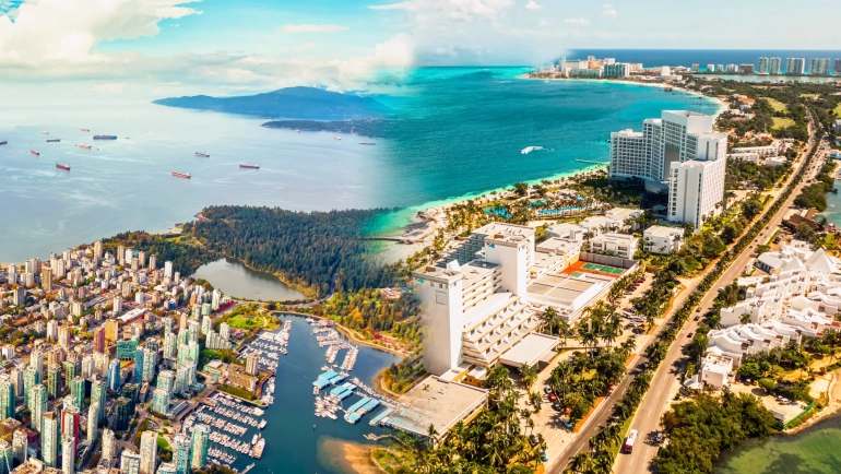 A split aerial view of Vancouver and Cancun, showing Vancouver’s harbor and Cancun’s turquoise coastline, representing flight routes between the two cities.